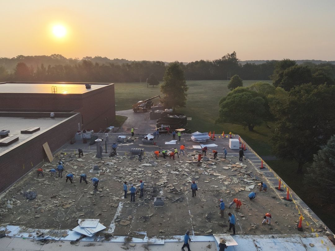 Amigo crew on a commercial flat-roof tear-off at sunrise